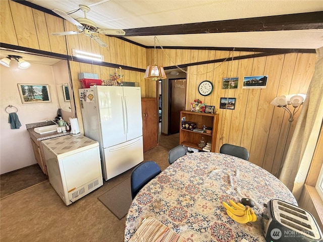 24 Hubbert Rd, Omak, WA 98841 - kitchen with freestanding refrigerator, wood walls, beam ceiling, a ceiling fan, and refrigerator