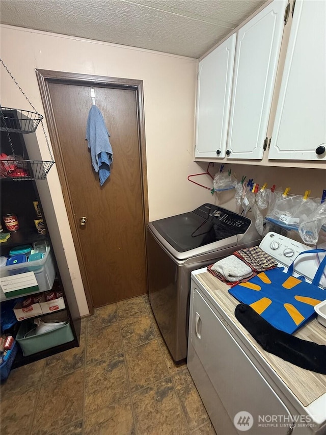24 Hubbert Rd, Omak, WA 98841 - laundry area featuring independent washer and dryer, cabinet space, stone finish flooring, and a textured ceiling