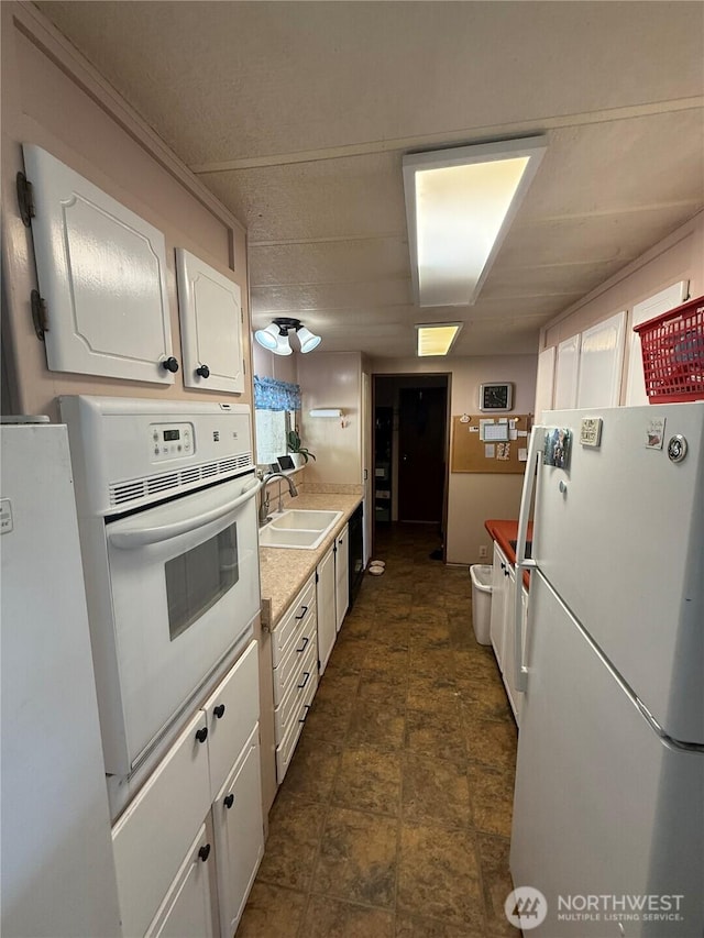 24 Hubbert Rd, Omak, WA 98841 - kitchen with white appliances, a sink, white cabinetry, light countertops, and stone finish floors
