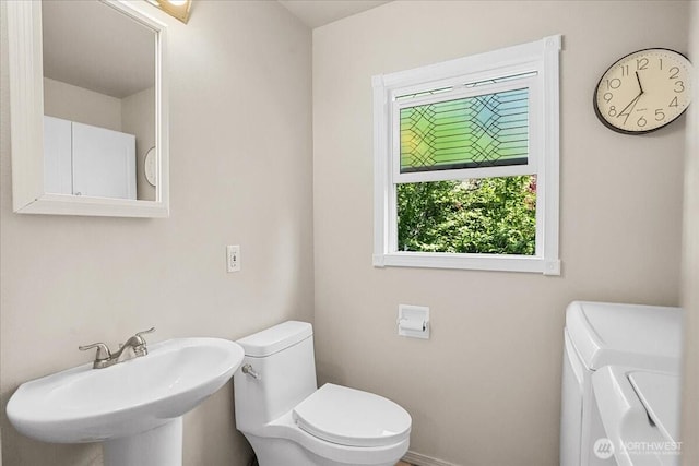6712 A St, Tacoma, WA 98408 - bathroom with washer and clothes dryer, toilet, a sink, and baseboards