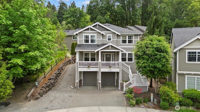 7320 111th Pl SE, Newcastle, WA 98056 - view of front facade featuring concrete driveway, stairway, an attached garage, covered porch, and stone siding