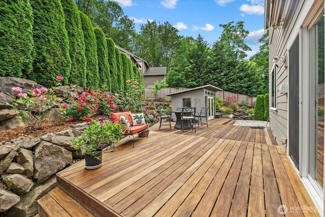 7320 111th Pl SE, Newcastle, WA 98056 - wooden terrace with outdoor dining area, a fenced backyard, and an outbuilding