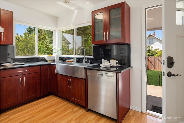 1210 S Mcclellan St, Seattle, WA 98144 - kitchen featuring stainless steel dishwasher, a sink, dark countertops, light wood finished floors, and plenty of natural light