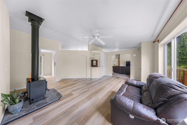 2957 Unick Rd, Ferndale, WA 98248 - living room with a wood stove, ceiling fan, and light wood-style flooring