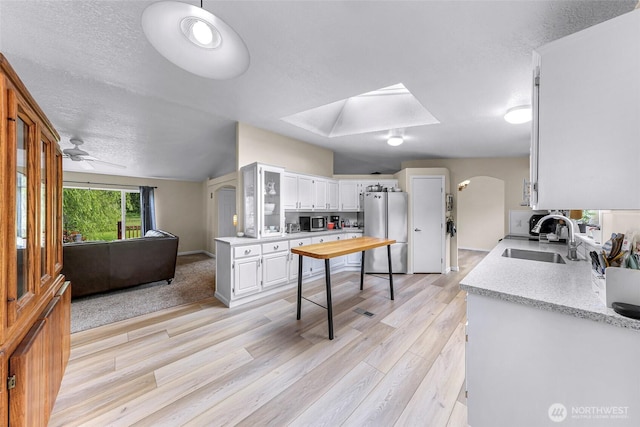 2957 Unick Rd, Ferndale, WA 98248 - kitchen with stainless steel appliances, a sink, light countertops, a skylight, and light wood-style floors