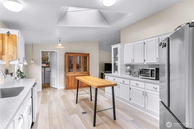 2957 Unick Rd, Ferndale, WA 98248 - kitchen with appliances with stainless steel finishes, a sink, washer and dryer, lofted ceiling, and white cabinets