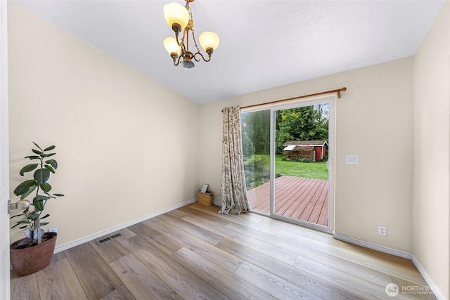 2957 Unick Rd, Ferndale, WA 98248 - unfurnished room featuring a chandelier, wood finished floors, and baseboards