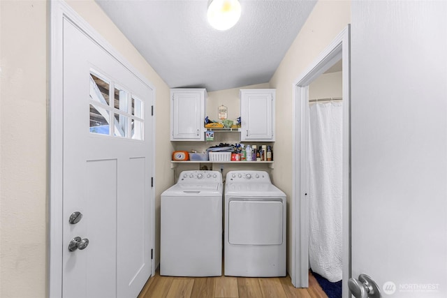 2957 Unick Rd, Ferndale, WA 98248 - laundry area featuring cabinet space, washer and clothes dryer, a textured ceiling, and light wood-type flooring