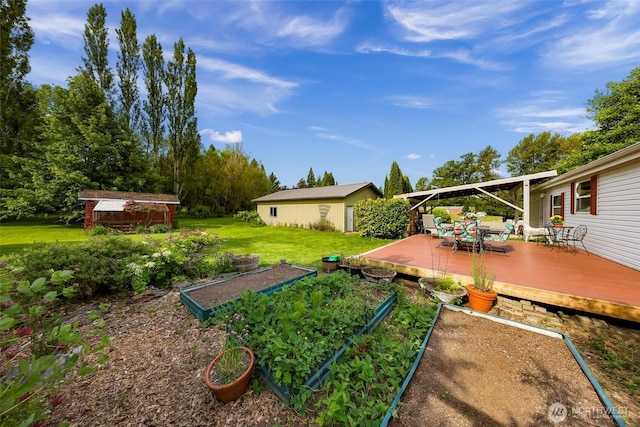 2957 Unick Rd, Ferndale, WA 98248 - view of grassy yard with a vegetable garden, a wooden deck, and an outdoor structure