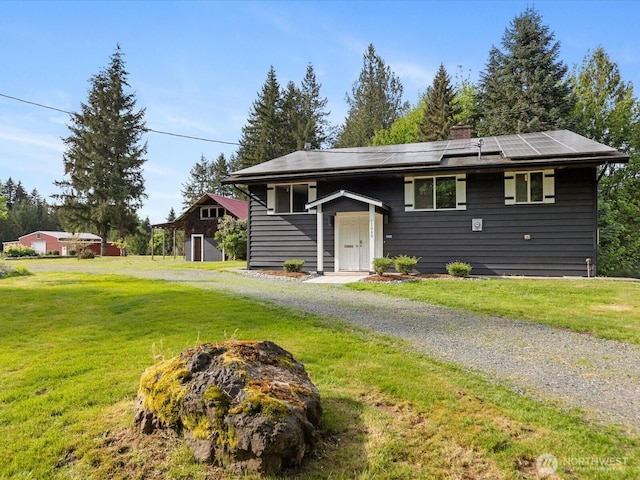 12020W Engebretsen Rd, Granite Falls, WA 98252 - view of front of property featuring roof mounted solar panels, a fire pit, and a front lawn