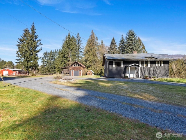 12020W Engebretsen Rd, Granite Falls, WA 98252 - view of front of house with solar panels, a front yard, a chimney, and driveway