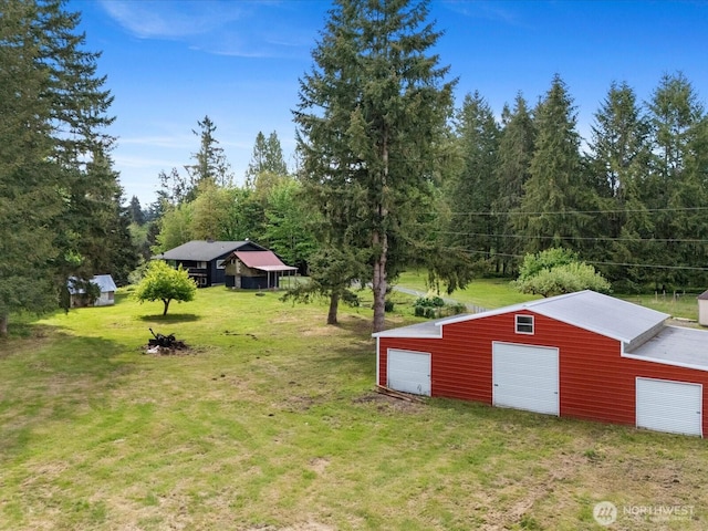 12020W Engebretsen Rd, Granite Falls, WA 98252 - view of grassy yard with a garage, an outdoor structure, and a forest view