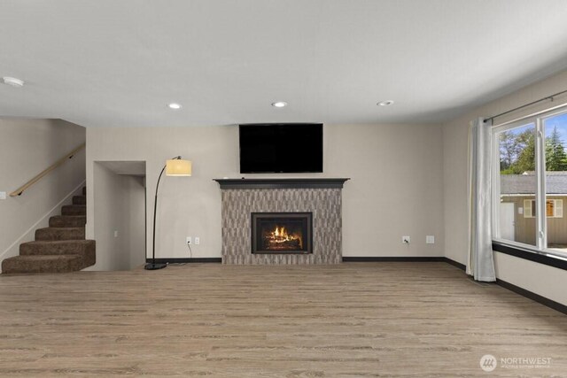 5208 S 380th St, Auburn, WA 98001 - unfurnished living room with wood finished floors, a warm lit fireplace, recessed lighting, and stairway