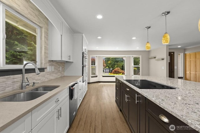 5208 S 380th St, Auburn, WA 98001 - kitchen featuring white cabinets, black electric cooktop, light wood-type flooring, pendant lighting, and recessed lighting