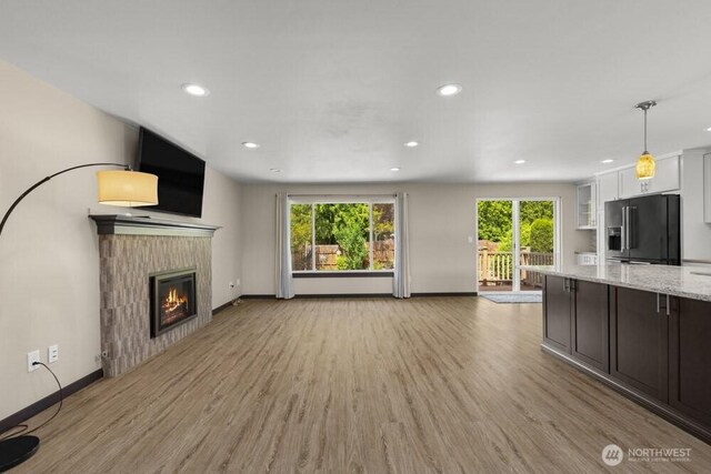 5208 S 380th St, Auburn, WA 98001 - unfurnished living room featuring light wood-style floors, a glass covered fireplace, and recessed lighting