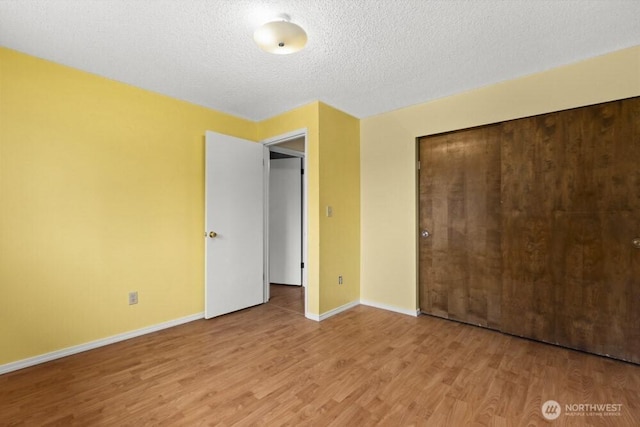 5208 S 380th St, Auburn, WA 98001 - unfurnished bedroom featuring wood finished floors, a closet, and a textured ceiling