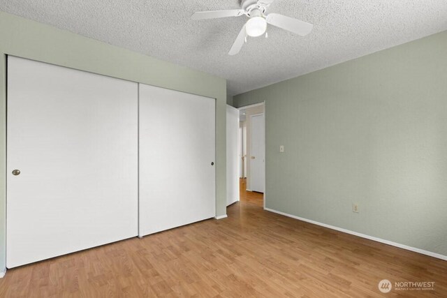 5208 S 380th St, Auburn, WA 98001 - unfurnished bedroom featuring a closet, light wood finished floors, a textured ceiling, and ceiling fan