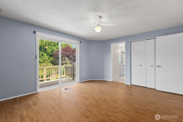 5208 S 380th St, Auburn, WA 98001 - unfurnished bedroom with access to outside, wood finished floors, a textured ceiling, connected bathroom, and a ceiling fan