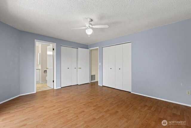5208 S 380th St, Auburn, WA 98001 - unfurnished bedroom featuring light wood-style flooring, multiple closets, a textured ceiling, ensuite bathroom, and a ceiling fan