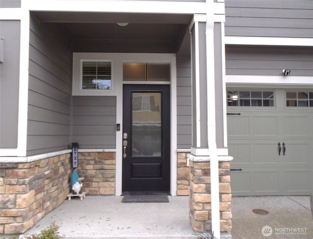 8727 E Gilman Ave, Arlington, WA 98223 - view of exterior entry with a garage and stone siding