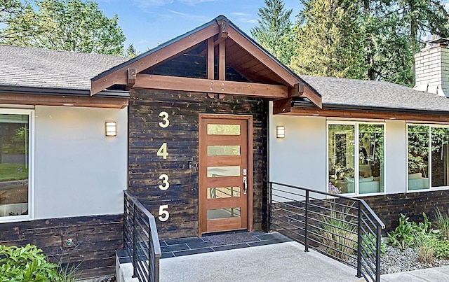 3435 103rd Pl NE, Bellevue, WA 98004 - doorway to property with a shingled roof, stucco siding, and a chimney