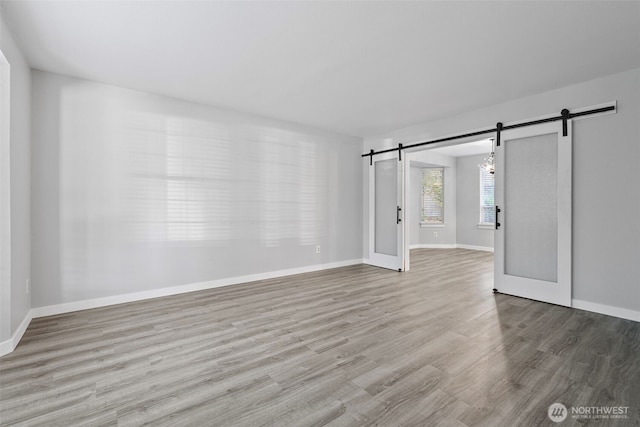 4426 82nd Avenue Ct W, University Place, WA 98466 - spare room featuring a barn door, wood finished floors, and baseboards