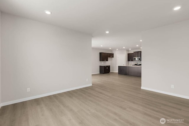 7402 281st Pl NW Unit 75, Stanwood, WA 98292 - unfurnished living room featuring recessed lighting, baseboards, and light wood-type flooring