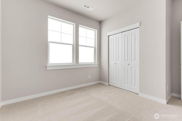 7402 281st Pl NW Unit 75, Stanwood, WA 98292 - unfurnished bedroom featuring light colored carpet, baseboards, and a closet
