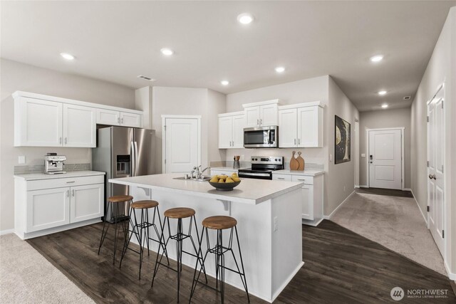 7402 281st Pl NW Unit 75, Stanwood, WA 98292 - kitchen with stainless steel appliances, a kitchen bar, light countertops, white cabinetry, and recessed lighting