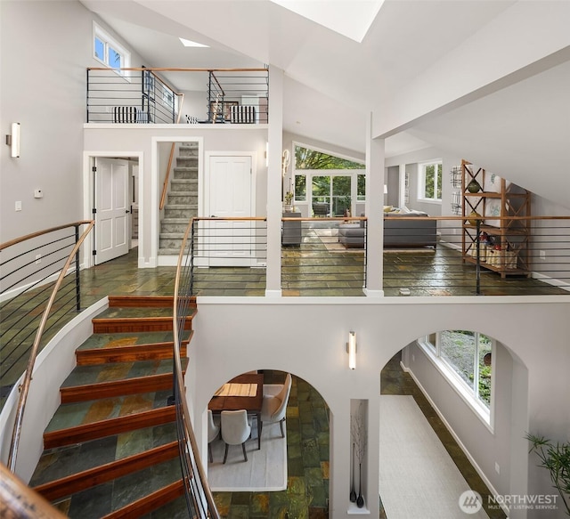 6819 SE 32nd St, Mercer Island, WA 98040 - staircase featuring a towering ceiling, a skylight, and baseboards