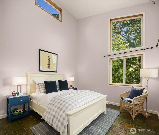 6819 SE 32nd St, Mercer Island, WA 98040 - bedroom with stone tile floors, multiple windows, baseboards, and a high ceiling