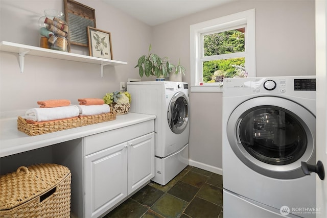 6819 SE 32nd St, Mercer Island, WA 98040 - washroom featuring washing machine and clothes dryer, baseboards, and dark stone finish floors