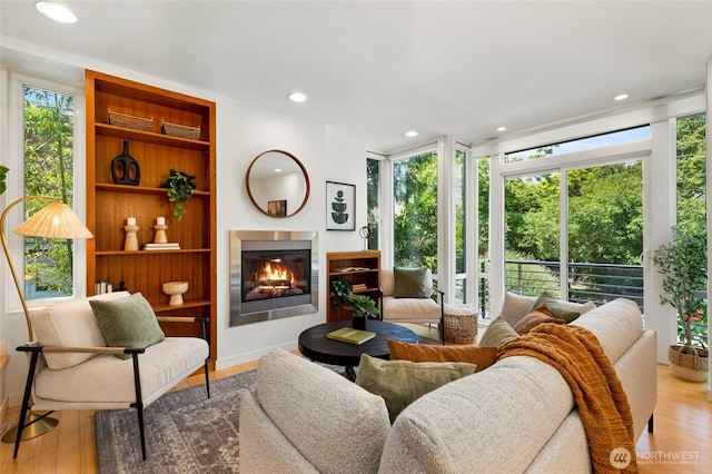 1805 N 36th St, Seattle, WA 98103 - living room with a glass covered fireplace, wood finished floors, built in features, and recessed lighting