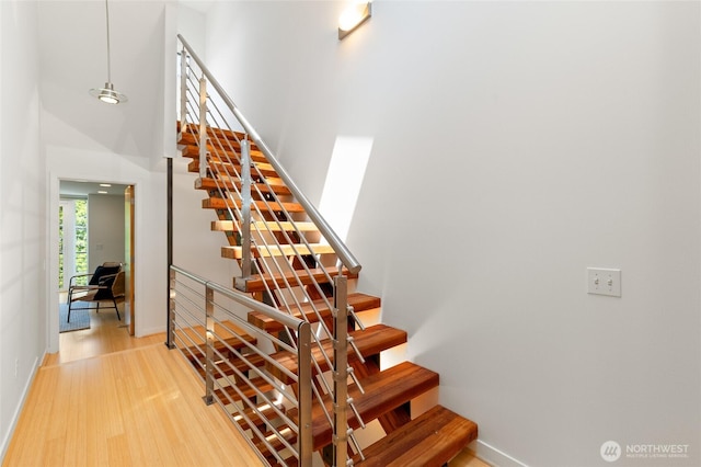 1805 N 36th St, Seattle, WA 98103 - stairs featuring baseboards, wood finished floors, and a towering ceiling