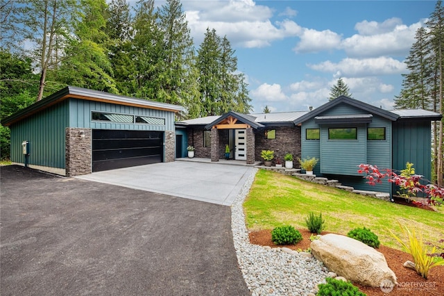 501 Vesper Way, Camano Island, WA 98282 - view of front facade featuring board and batten siding, a front yard, stone siding, and a garage