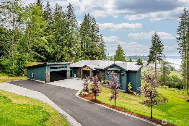 501 Vesper Way, Camano Island, WA 98282 - view of front facade featuring a front lawn, a detached garage, a standing seam roof, stone siding, and metal roof