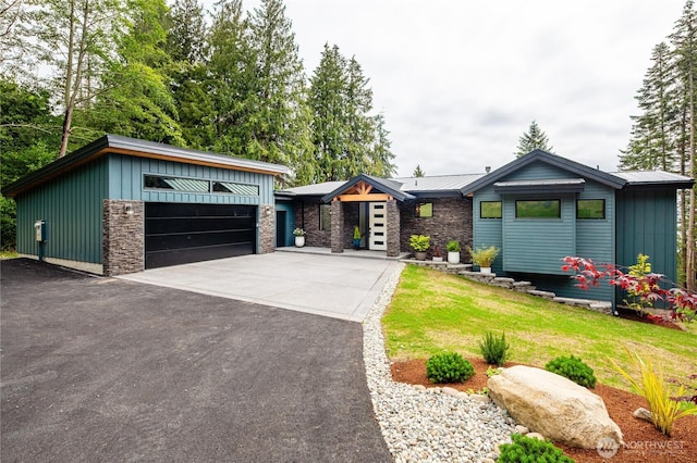 501 Vesper Way, Camano Island, WA 98282 - view of front of property with board and batten siding, a front yard, stone siding, and a detached garage