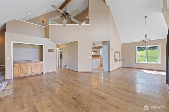 42480 N State Route 25, Davenport, WA 99122 - unfurnished living room with high vaulted ceiling, a chandelier, a ceiling fan, light wood-style flooring, and baseboards