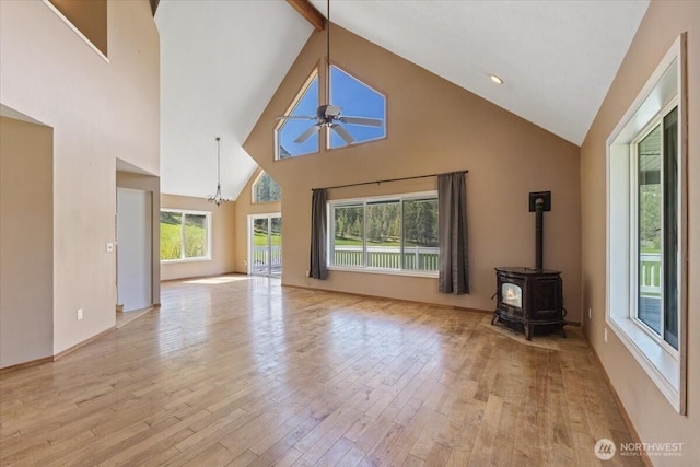 42480 N State Route 25, Davenport, WA 99122 - unfurnished living room featuring high vaulted ceiling, ceiling fan, light wood-style flooring, a wood stove, and a chandelier