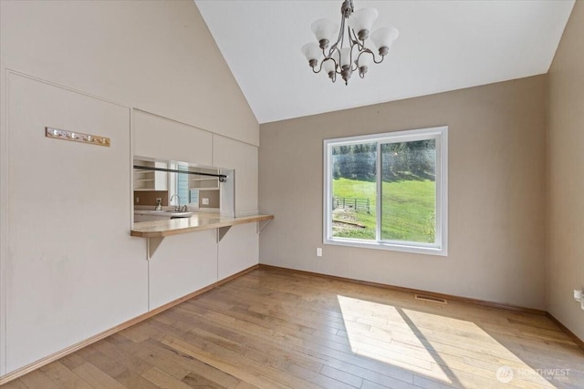 42480 N State Route 25, Davenport, WA 99122 - unfurnished dining area with a chandelier, light wood-style floors, a sink, high vaulted ceiling, and baseboards