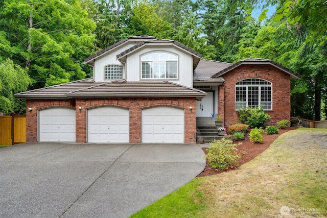 10411 23rd Street Ct E, Edgewood, WA 98372 - tri-level home with a tiled roof, concrete driveway, brick siding, and a garage