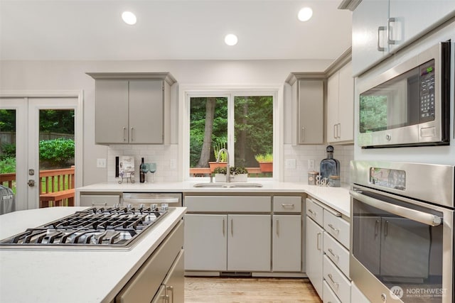 10411 23rd Street Ct E, Edgewood, WA 98372 - kitchen with appliances with stainless steel finishes, gray cabinetry, light countertops, tasteful backsplash, and recessed lighting