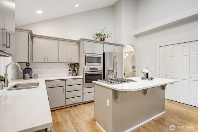 10411 23rd Street Ct E, Edgewood, WA 98372 - kitchen with stainless steel appliances, high vaulted ceiling, light countertops, backsplash, and arched walkways