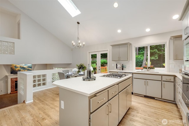 10411 23rd Street Ct E, Edgewood, WA 98372 - kitchen with stainless steel gas stovetop, a skylight, light wood-type flooring, light countertops, and recessed lighting