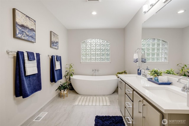 10411 23rd Street Ct E, Edgewood, WA 98372 - bathroom with double vanity, a freestanding tub, recessed lighting, and marble look tile flooring