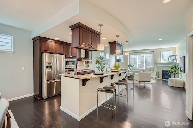 10502 SE 10th Ct Unit 9, Bellevue, WA 98004 - kitchen featuring stainless steel appliances, wall chimney range hood, light stone counters, dark wood-style floors, and open floor plan