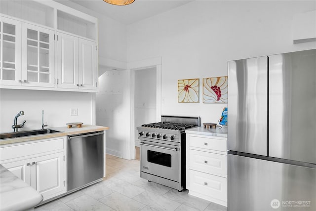 2008 Nob Hill Ave N, Seattle, WA 98119 - kitchen with stainless steel appliances, a sink, light countertops, and glass insert cabinets