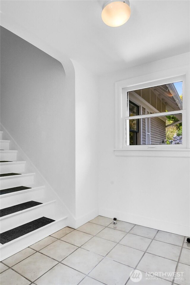2008 Nob Hill Ave N, Seattle, WA 98119 - empty room featuring light tile patterned floors, baseboards, and stairway