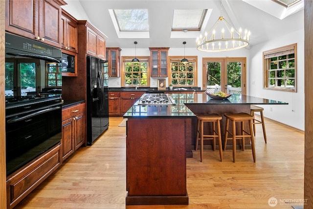 2020 Evergreen Point Rd, Medina, WA 98039 - kitchen featuring black appliances, a center island, a sink, dark countertops, and a breakfast bar area