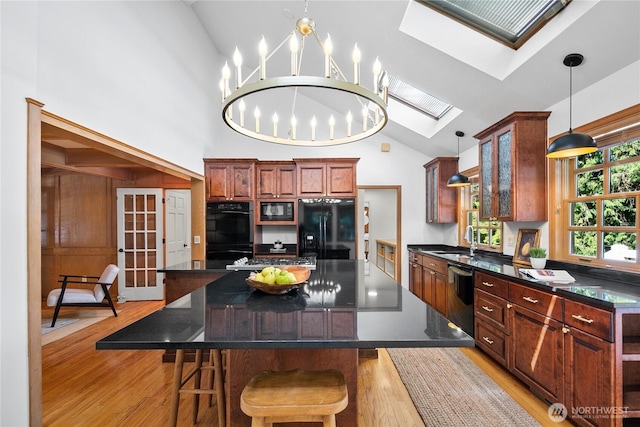 2020 Evergreen Point Rd, Medina, WA 98039 - kitchen with black appliances, a skylight, a sink, light wood finished floors, and high vaulted ceiling